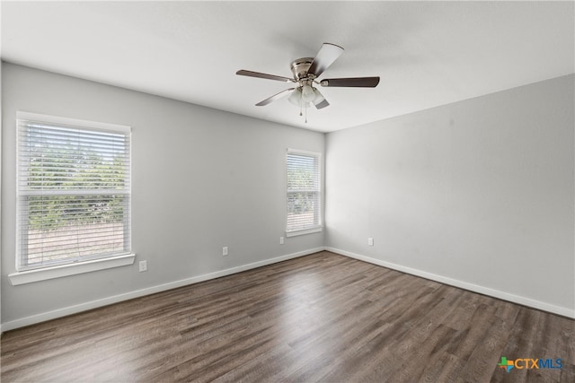 spare room featuring a ceiling fan, wood finished floors, and baseboards