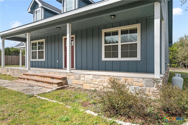 doorway to property with board and batten siding and covered porch