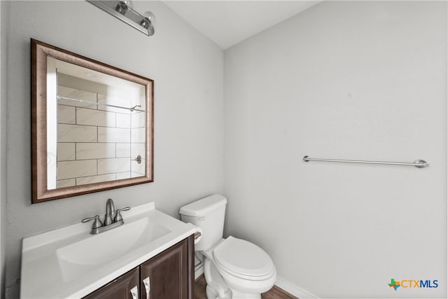 bathroom with vanity, toilet, and baseboards