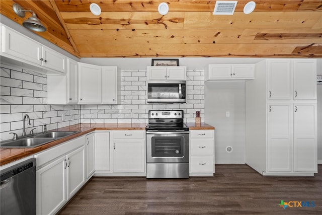 kitchen with visible vents, a sink, vaulted ceiling, appliances with stainless steel finishes, and dark wood-style flooring