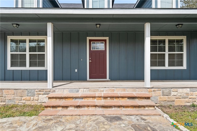 view of exterior entry featuring covered porch