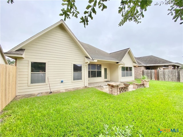 back of house with a lawn and a patio area