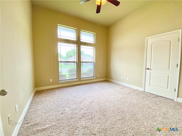 carpeted spare room with ceiling fan