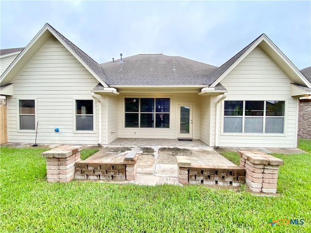 rear view of house with a lawn and a patio