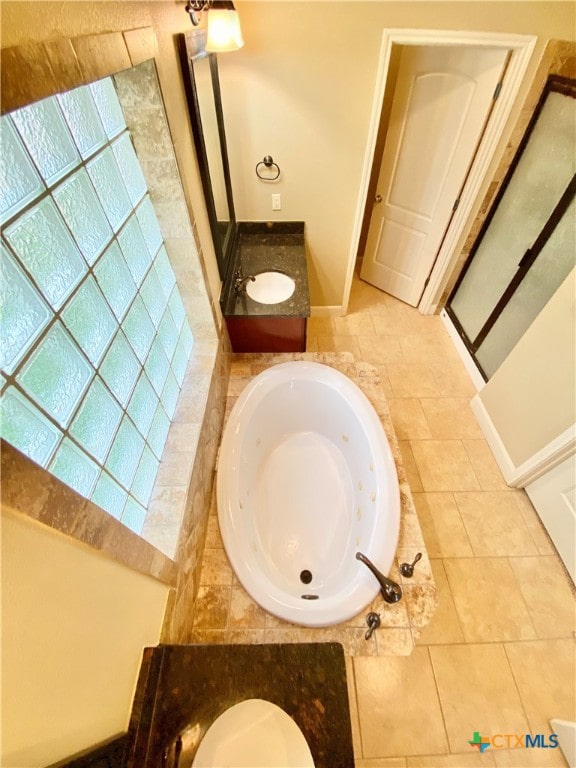 bathroom featuring vanity, tiled tub, and tile patterned floors