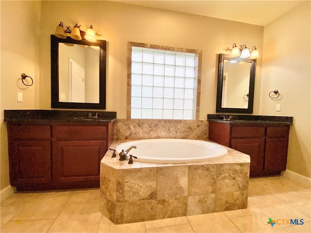 bathroom featuring vanity, tile patterned flooring, and tiled tub