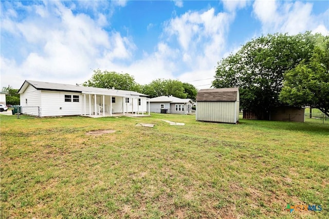 view of yard with fence, a storage unit, an outdoor structure, and a patio area