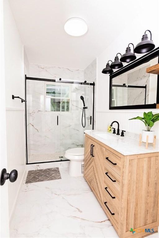 2111 Brantley Ave, Copperas Cove, TX 76522 - full bathroom featuring a marble finish shower, toilet, marble finish flooring, a wainscoted wall, and vanity