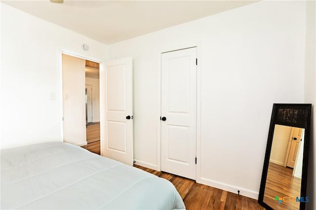 bedroom featuring baseboards and wood finished floors