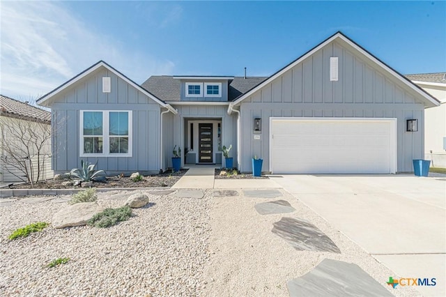 view of front of property featuring a garage, board and batten siding, concrete driveway, and a shingled roof