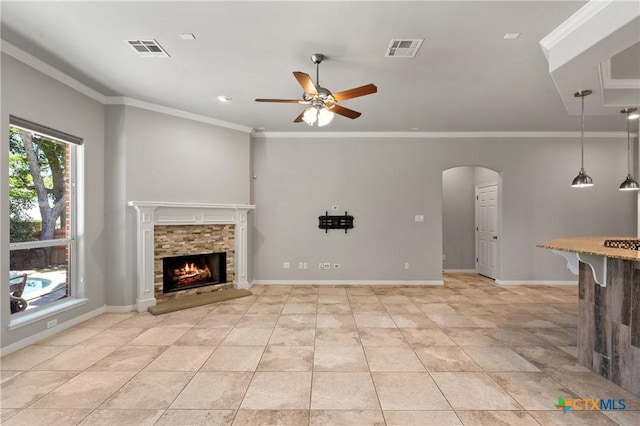 5905 Turtle Creek Trl, Temple, TX 76502 - unfurnished living room featuring ceiling fan, a fireplace, crown molding, light tile patterned flooring, and arched walkways