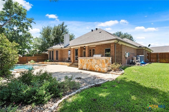5905 Turtle Creek Trl, Temple, TX 76502 - rear view of house with area for grilling, a patio, brick siding, and a chimney