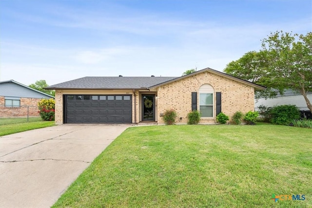view of front of property with an attached garage, driveway, a front yard, and brick siding
