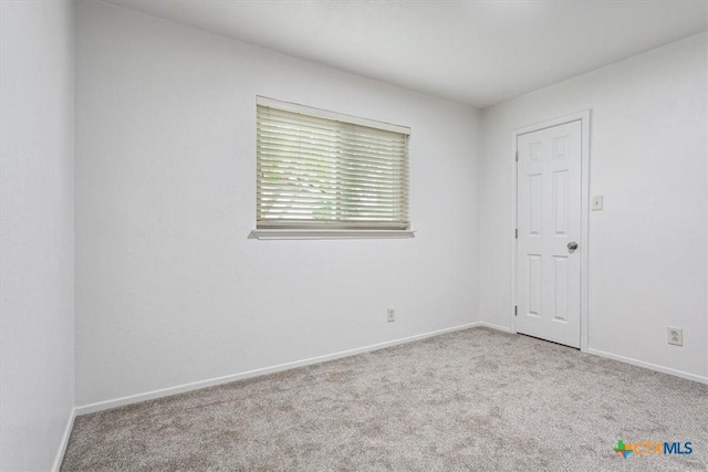 spare room with carpet and baseboards