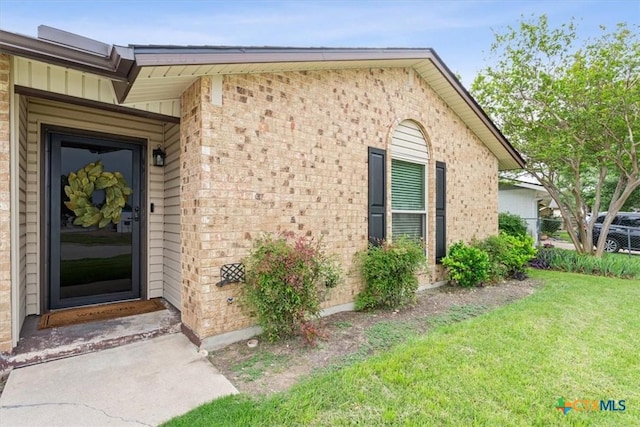 view of exterior entry with brick siding