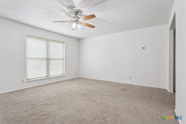 carpeted spare room with a ceiling fan, a textured ceiling, and baseboards