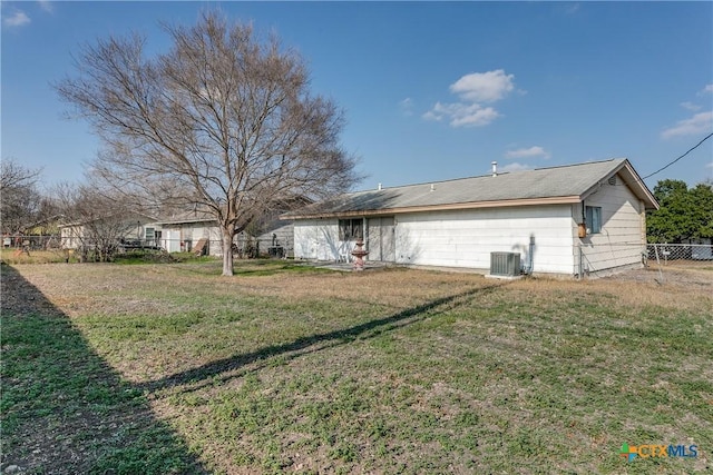 back of house with central AC and a lawn