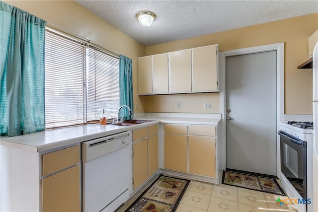 kitchen with sink, white appliances, and a textured ceiling