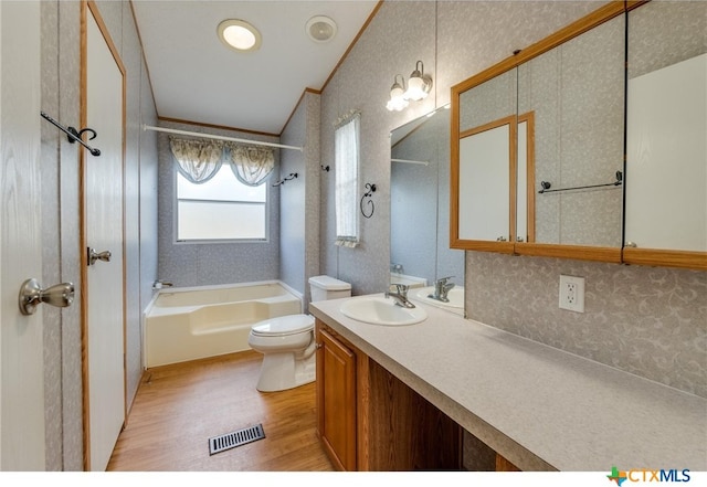 full bathroom with washtub / shower combination, hardwood / wood-style floors, vanity, crown molding, and toilet