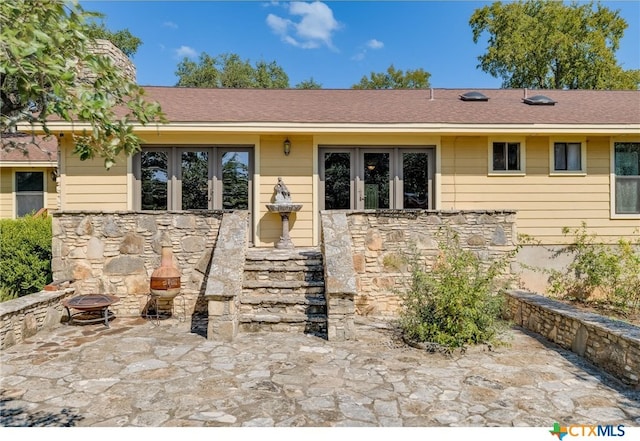 single story home featuring a fire pit and a patio area