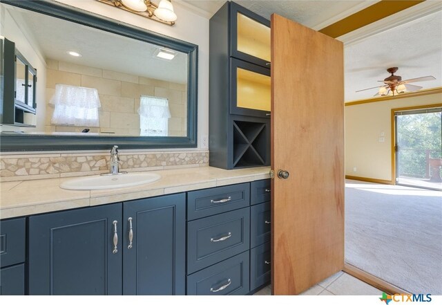 bathroom with ornamental molding, vanity, and ceiling fan