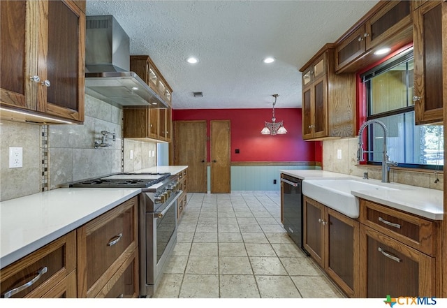 kitchen featuring black dishwasher, pendant lighting, sink, stainless steel range, and wall chimney exhaust hood