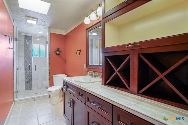 bathroom with toilet, tile patterned floors, a textured ceiling, vanity, and a skylight