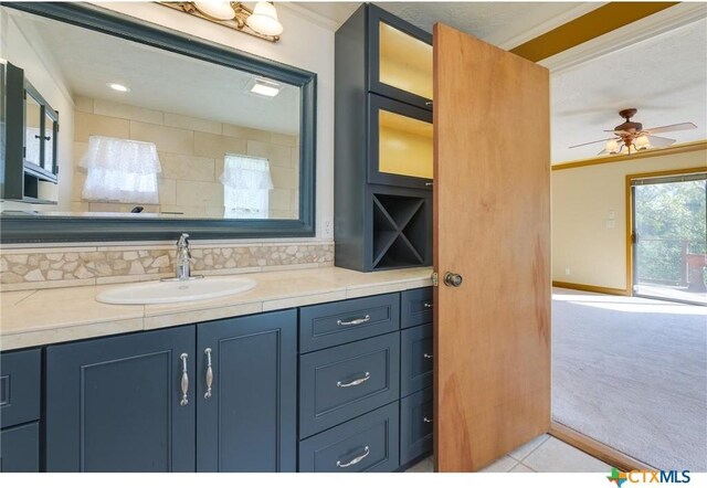 spare room featuring a textured ceiling, light carpet, ceiling fan, and crown molding