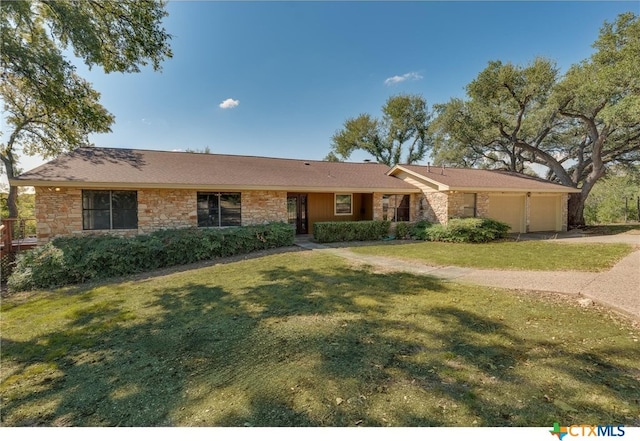 single story home featuring a garage, stone siding, and a front lawn