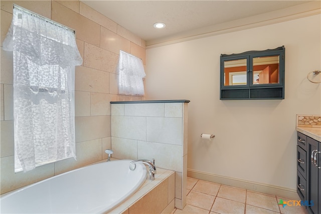 bathroom featuring a relaxing tiled tub, vanity, tile patterned floors, and crown molding