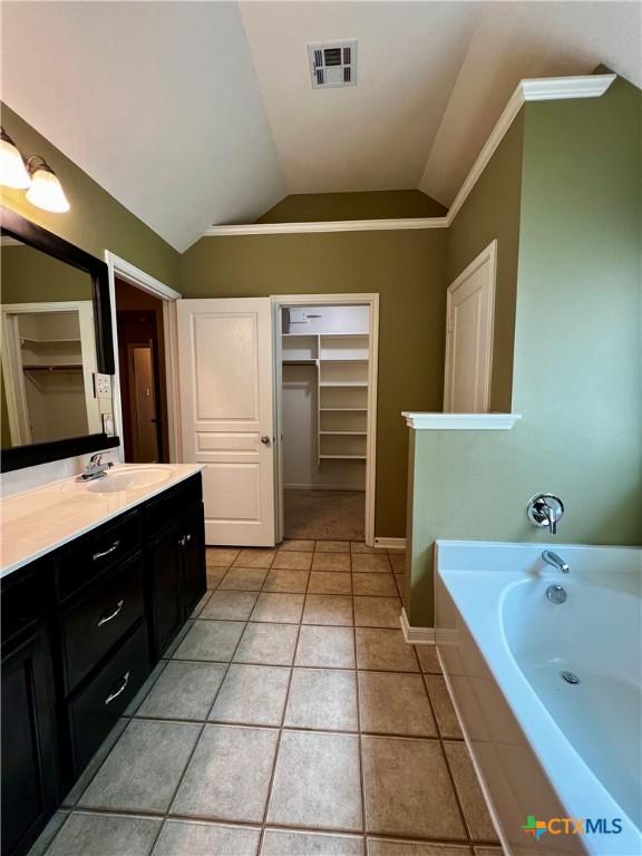 5832 Alexandria Dr, Temple, TX 76502 - full bath featuring lofted ceiling, vanity, a bath, a spacious closet, and tile patterned floors