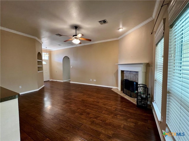 5832 Alexandria Dr, Temple, TX 76502 - unfurnished living room featuring a ceiling fan, dark wood-style flooring, arched walkways, crown molding, and a fireplace