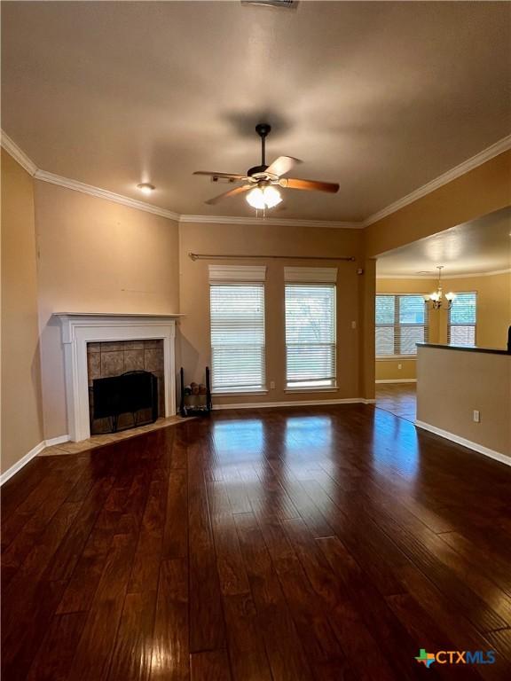 5832 Alexandria Dr, Temple, TX 76502 - unfurnished living room featuring a tile fireplace, hardwood / wood-style flooring, a ceiling fan, a chandelier, and ornamental molding
