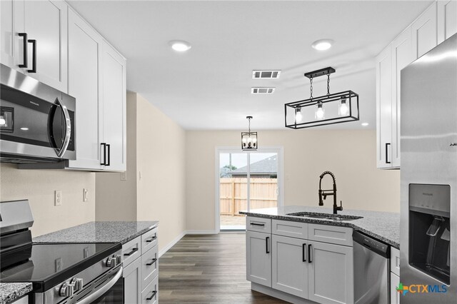 5224 Rose Garden Loop, Killeen, TX 76542 - kitchen with stainless steel appliances, a sink, a peninsula, dark wood-type flooring, and stone countertops