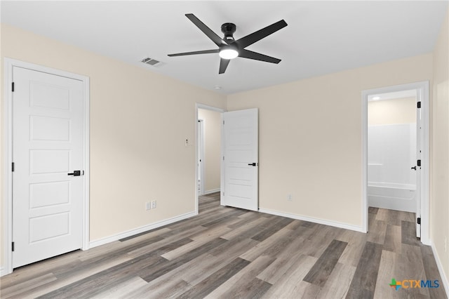 5224 Rose Garden Loop, Killeen, TX 76542 - unfurnished bedroom with wood finished floors, baseboards, connected bathroom, and a ceiling fan