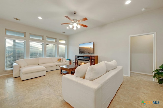 living room with a wealth of natural light, light tile patterned floors, and ceiling fan