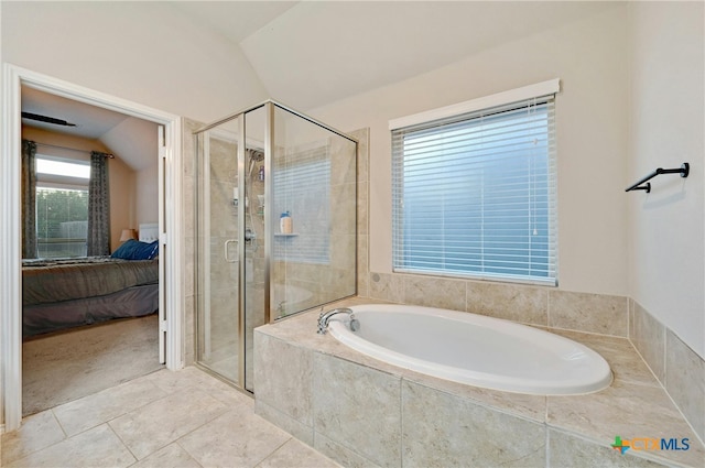 ensuite bathroom featuring lofted ceiling, a stall shower, a bath, and tile patterned floors