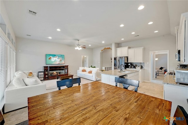 dining area with ceiling fan, recessed lighting, and a multi sided fireplace