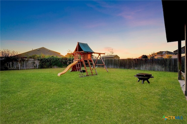 playground at dusk featuring a yard