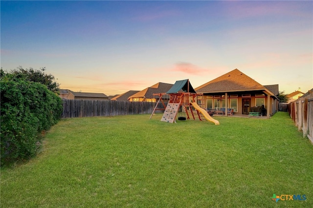 playground at dusk featuring a lawn