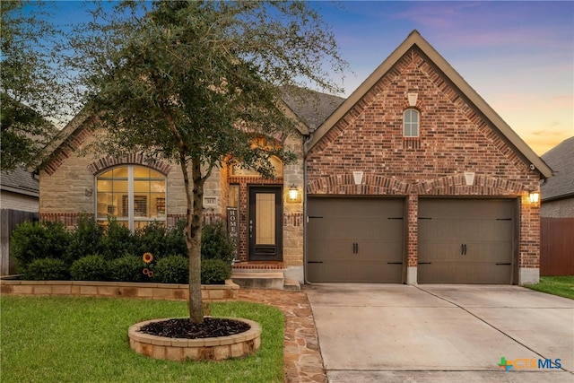 view of front of house featuring driveway, brick siding, and fence