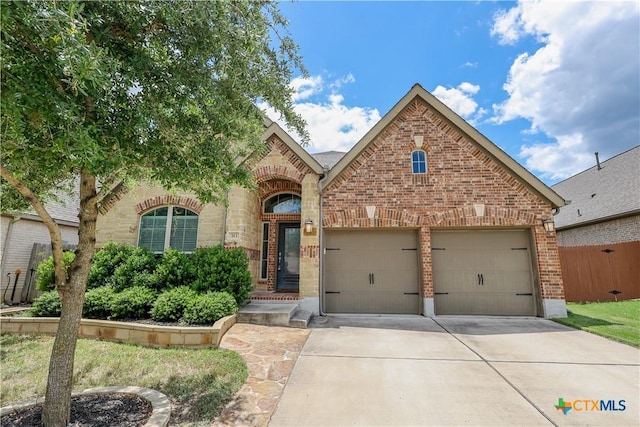 313 Durata Dr, San Marcos, TX 78666 - view of front of home with driveway, brick siding, and an attached garage