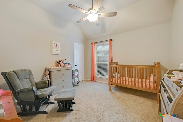 bedroom featuring lofted ceiling, carpet, a crib, ceiling fan, and baseboards