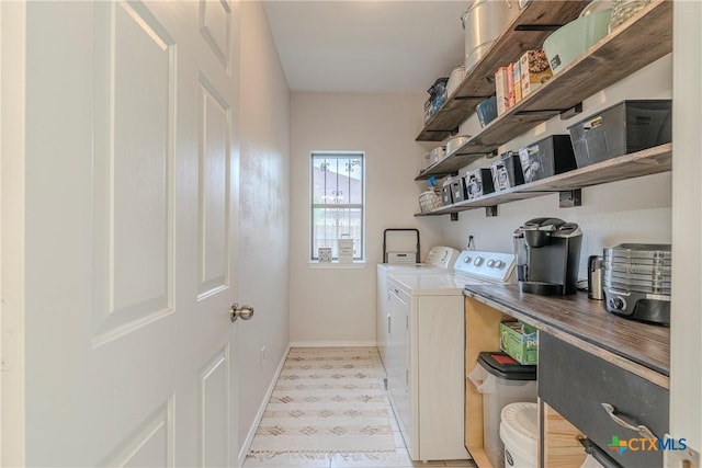 washroom featuring independent washer and dryer, laundry area, baseboards, and light floors