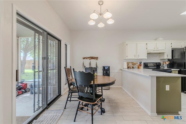 kitchen featuring black appliances, plenty of natural light, under cabinet range hood, and an inviting chandelier