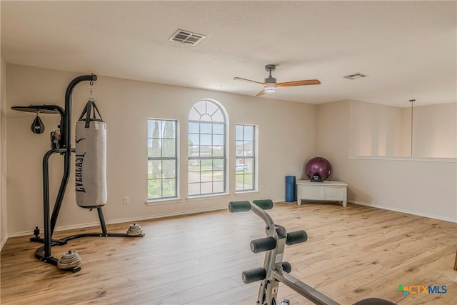 exercise area with baseboards, ceiling fan, visible vents, and wood finished floors