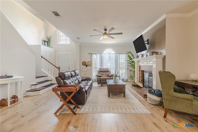 living room with a wealth of natural light, stairway, and light wood-style floors