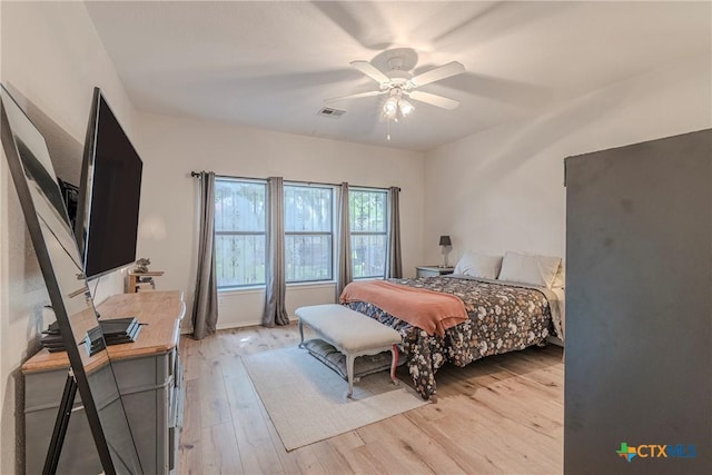 bedroom featuring light wood-style floors, a ceiling fan, and visible vents