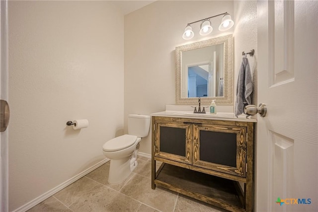 bathroom featuring baseboards, tile patterned floors, toilet, and vanity
