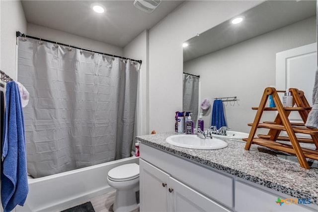 full bathroom featuring vanity, shower / bath combo, and toilet